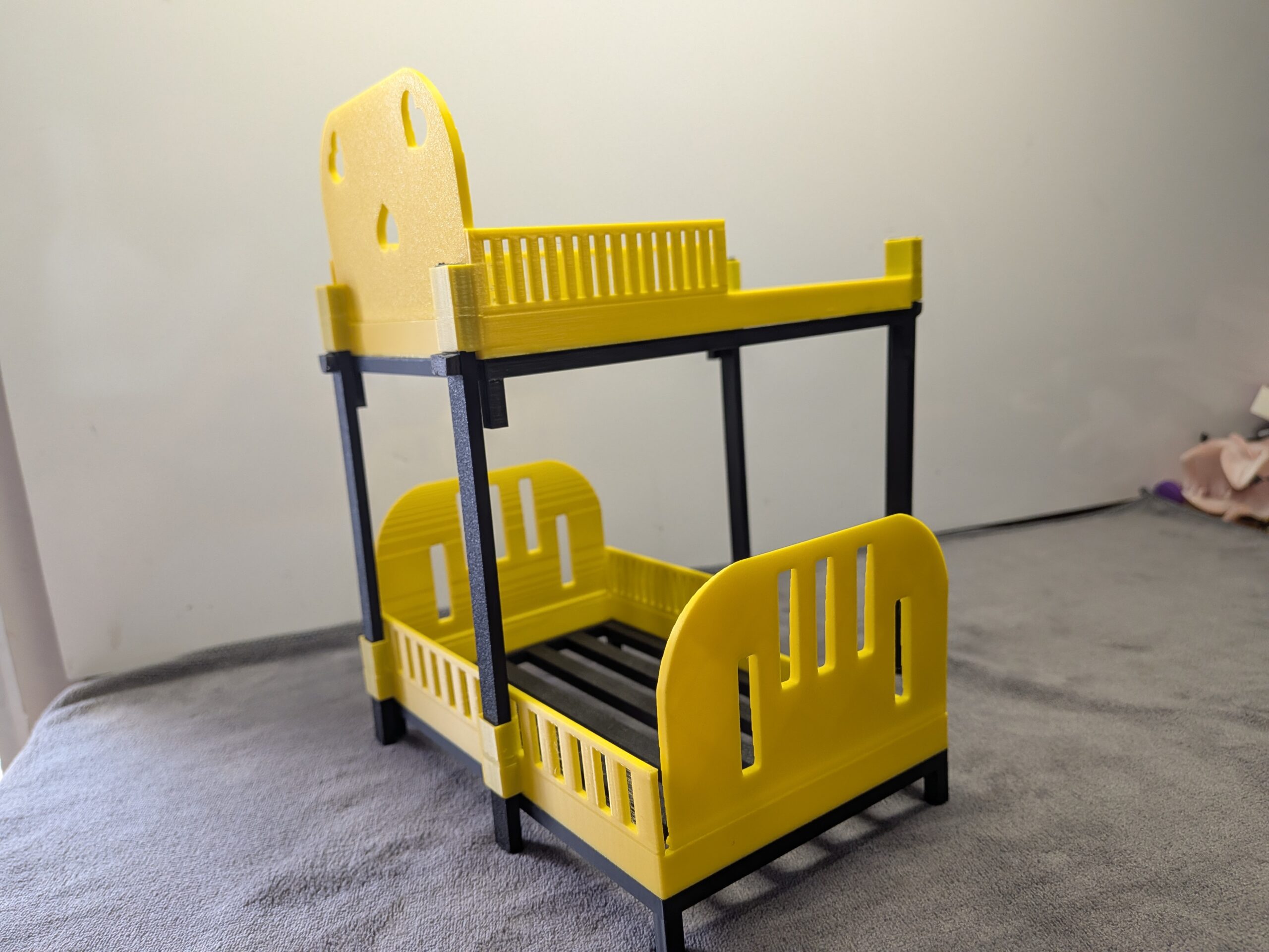 Modern 1:12 scale 3D printed stackable bunk beds for dollhouses in bright yellow with black frames and slatted bases.