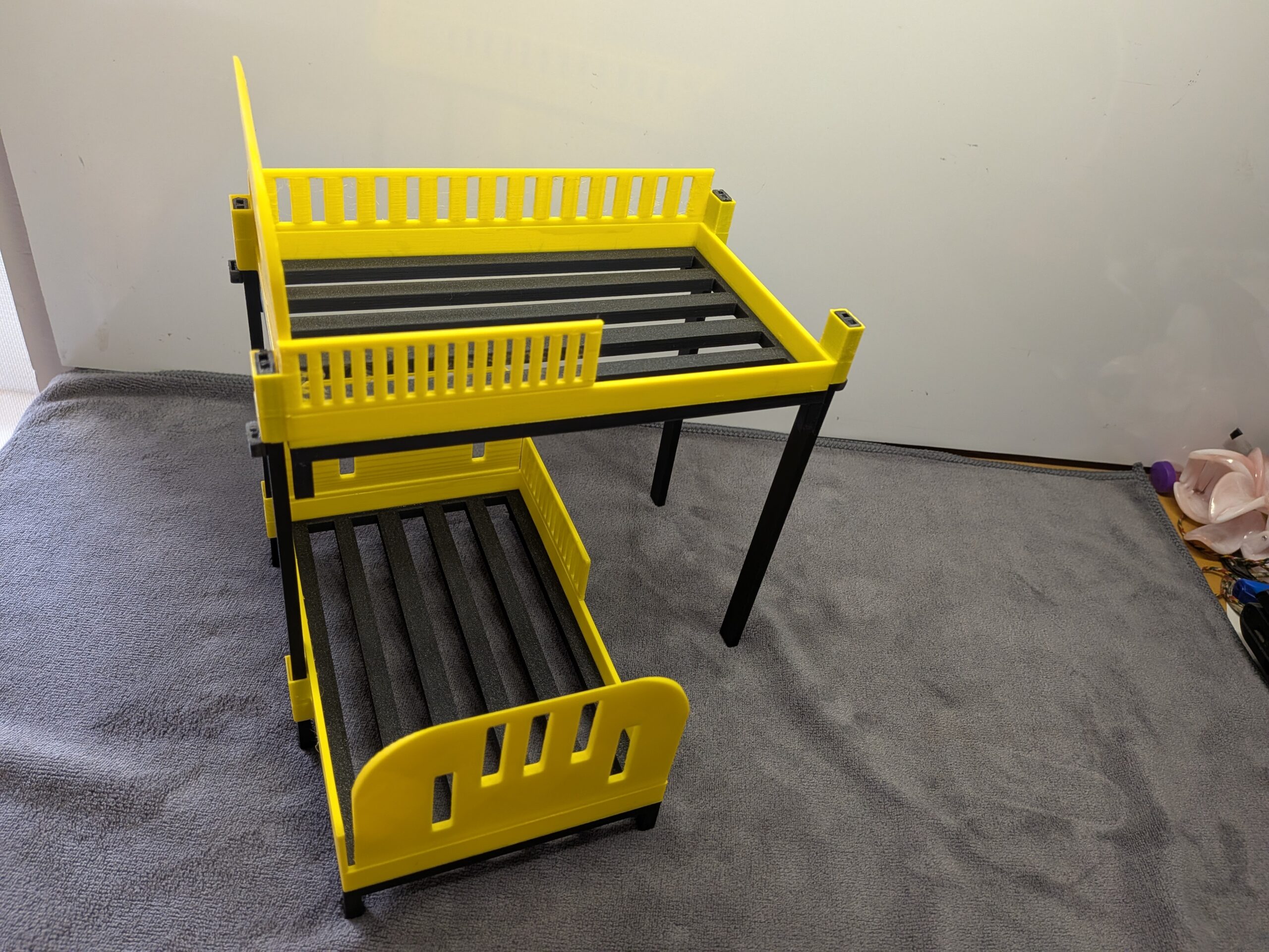 Modern 1:12 scale 3D printed stackable bunk beds for dollhouses in bright yellow with black frames and slatted bases.