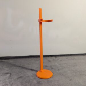 Vibrant orange 3D printed doll display stand featuring a round base and adjustable waist clip, shown supporting a fashion doll.