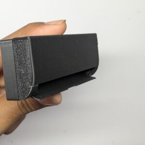 Modern matte black 3D printed miniature split AC unit for a 1:12 scale dollhouse, featuring realistic vent details and a sleek rectangular design.
